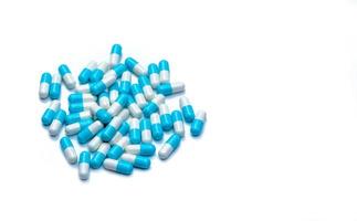 tas de pilules capsules bleues et blanches isolées sur fond blanc avec espace de copie. concept de soins de santé mondial. la résistance aux antibiotiques. gélules antimicrobiennes. industrie pharmaceutique. photo