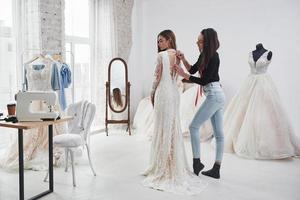 presque fini. le processus d'essayage de la robe dans l'atelier de vêtements fabriqués à la main photo