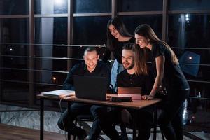 dormir pour les faibles. une équipe de jeunes hommes d'affaires travaille sur leur projet la nuit au bureau photo