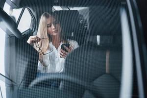 conception d'images abstraites. une femme d'affaires intelligente est assise à l'arrière de la voiture de luxe à l'intérieur noir photo