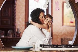 étreinte spontanée. grand-mère et petite-fille s'amusent à la cuisine à Pâques photo