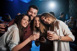 câlins amicaux. belle jeunesse fait la fête avec de l'alcool dans la discothèque photo