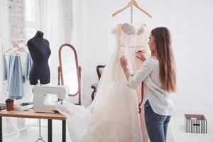 créer une belle robe. la créatrice de mode féminine travaille sur les nouveaux vêtements de l'atelier photo