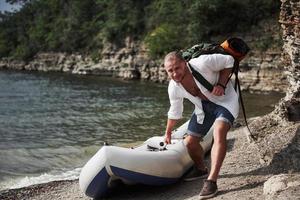 un jeune homme voyage avec un sac à dos à l'aide d'un bateau. le mode de vie du voyage et de la nature avec la nature photo