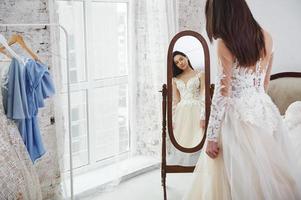 se prépare pour le mariage. le processus d'essayage de la robe dans l'atelier de vêtements fabriqués à la main photo