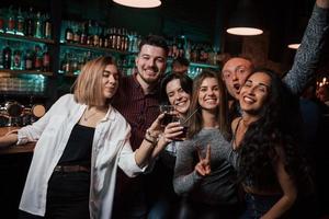 yeux heureux. belle jeunesse fait la fête avec de l'alcool dans la discothèque photo