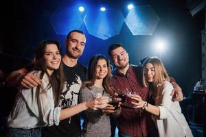 c'est si bon d'être à nouveau ensemble. groupe de jeunes amis souriant et portant un toast dans la discothèque photo