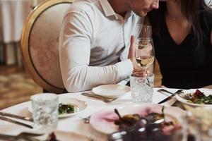 parle tranquillement de certaines choses. un beau couple dîne romantique dans un restaurant de luxe le soir photo