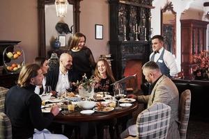 passer une commande s'il vous plait. amis de la famille s'amusant dans un beau restaurant moderne de luxe photo