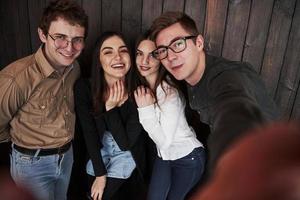 se sentir satisfait. prendre des selfies. gros plan vue de face d'amis. homme à lunettes de soleil dans la chambre photo