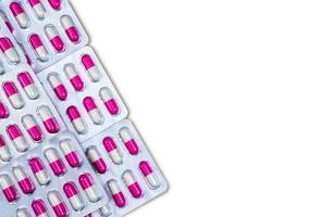 pilules de capsule antibiotique rose, blanc sous blister isolé sur fond blanc. médecine pour les maladies infectieuses. antibiotique utilisé chez les animaux destinés à l'alimentation dans les fermes d'animaux propagation de la résistance aux antibiotiques photo