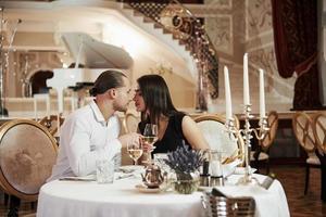 les yeux fermés. un beau couple dîne romantique dans un restaurant de luxe le soir photo