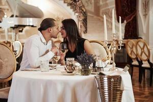 moment que vous attendiez. un beau couple dîne romantique dans un restaurant de luxe le soir photo