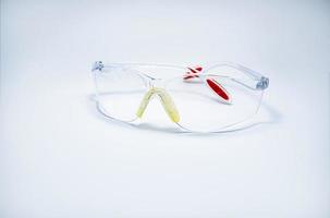 lunettes de sécurité en plastique isolés sur fond blanc. lunettes de protection pour les yeux du travailleur sur le chantier ou en usine. outils de sécurité et de sûreté sur le lieu de travail. utilisation de lunettes de protection en laboratoire photo