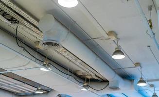 conduit d'air, câblage et plomberie dans le centre commercial. tuyau de climatiseur, tuyau de câblage et système de tuyauterie de plomberie. concept d'intérieur de bâtiment. plafonnier lumière avec lumière ouverte. notion d'architecture d'intérieur. photo