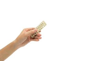 main de femme prenant des pilules contraceptives. femme adulte asiatique tenant un paquet de pilules contraceptives isolé sur fond blanc avec un tracé de détourage. choisir la planification familiale avec le concept de pilules contraceptives photo