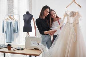 ça a l'air cool. le processus d'essayage de la robe dans l'atelier de vêtements fabriqués à la main photo