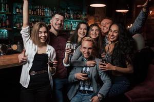 Gens charmants. belle jeunesse fait la fête avec de l'alcool dans la discothèque photo