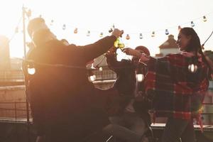 guitare et alcool. c'est la fête sur le toit. groupe d'amis en vacances le jour d'automne ensoleillé photo