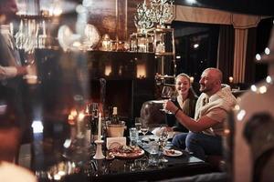 serveur à travers le verre. fille avec son petit ami passe une bonne soirée dans un beau restaurant photo