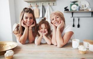 joli portrait. mère, grand-mère et fille s'amusant dans la cuisine photo