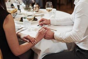 tendresse entre ces deux amants. un beau couple dîne romantique dans un restaurant de luxe le soir photo