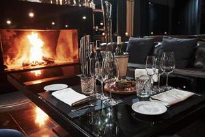 endroit parfait pour passer du temps de luxe. salle calme au restaurant avec table pleine de coupes de champagne et belle cheminée photo