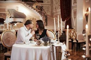 scène classique avec de nombreuses bougies et amoureux. un beau couple dîne romantique dans un restaurant de luxe le soir photo