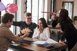 gâteau et ballons. l'un des employés fête son anniversaire aujourd'hui. des collègues amicaux décident de lui faire une surprise photo