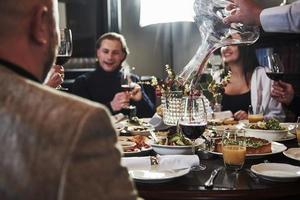 parler de certains événements. amis de la famille s'amusant dans un beau restaurant moderne de luxe photo