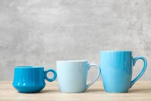 tasse à café bleue et tasse à thé sur fond de table en bois le matin, espace de copie vierge pour le texte. journée internationale du café et concept de routine quotidienne photo