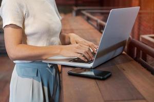 femme d'affaires décontractée utilisant un ordinateur portable, femme indépendante tapant un ordinateur portable au clavier dans un café ou un bureau moderne. technologie, numérique en ligne et concept de réseau photo