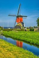 moulins à vent et canal d'eau à kinderdijk, en hollande ou aux pays-bas. photo