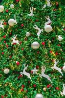 gros plan sur la décoration d'arbre de noël avec des boules rouges, dorées, argentées et blanches, une étoile argentée et un renne blanc. fond de Noël. fond de noël et bonne année. boule colorée sur le sapin de Noël. photo