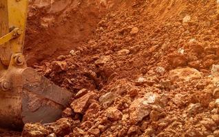 godet de rétrocaveuse creusant le sol à la ferme agricole pour faire un étang. pelle sur chenilles creusant dans la couche de schiste. engin d'excavation. matériel de terrassement. véhicule d'excavation. entreprise de construction. photo