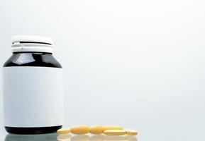 comprimés comprimés de vitamine c 1 000 mg sur fond blanc et bouteille ambre avec étiquette vierge et espace de copie pour le texte. concept de vitamines et de suppléments. antioxydant photo