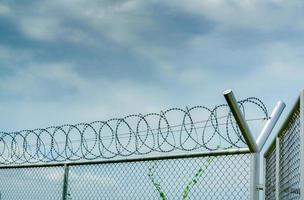 barrière de sécurité de la prison. clôture de sécurité en fil de fer barbelé. clôture de prison en barbelés. frontière barrière. mur de sécurité frontalier. prison pour arrêter des criminels ou des terroristes. zone privée. notion de zone militaire. photo