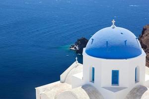 ville d'oia sur l'île de santorin, grèce. église blanche au dôme bleu. photo