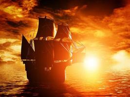 ancien bateau pirate naviguant sur l'océan au coucher du soleil photo