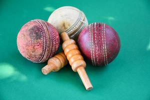 gros plan vieux équipements de sport de cricket sur sol vert, vieille balle en cuir et guichets en bois, mise au point douce et sélective, amateurs de sport de cricket traditionnels autour du concept mondial. photo