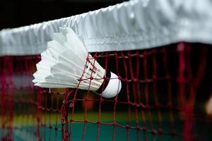 équipements de sport de badminton sur volants de sol vert, raquettes, chaussures, mise au point sélective sur les volants, concept d'amant de sport de badminton. photo
