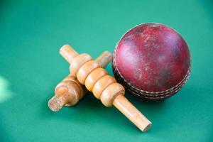 gros plan vieux équipements de sport de cricket sur sol vert, vieux ballon en cuir et guichets en bois, mise au point douce et sélective, amateurs de sport de cricket traditionnels autour du concept mondial. photo