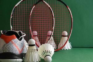 équipements de sport de badminton sur le sol vert du terrain de badminton volants, raquettes, chaussures, mise au point sélective sur les volants, sport de badminton jouant aux amoureux du concept mondial. photo