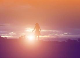 silhouette de femme priant sur fond de ciel magnifique photo