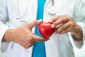 médecin tenant un coeur rouge dans la salle d'hôpital, concept médical solide et sain. photo