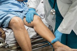 Une patiente asiatique âgée ou âgée montre ses cicatrices Chirurgie de remplacement total de l'articulation du genou Chirurgie des plaies arthroplastie sur lit dans la salle d'hôpital de soins infirmiers, concept médical solide et sain. photo