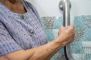 Une patiente asiatique âgée ou âgée utilise la sécurité de la poignée de la salle de bain des toilettes dans la salle d'hôpital de soins infirmiers, concept médical solide et sain. photo