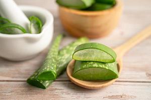 aloe vera avec des tranches sur fond de bois, plante médicinale pour la santé et la beauté. photo