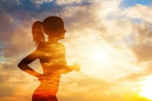 silhouette d'une femme en cours d'exécution sur fond de ciel. photo