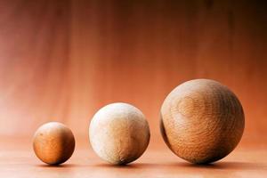 trois boules en bois sur une planche en bois. photo